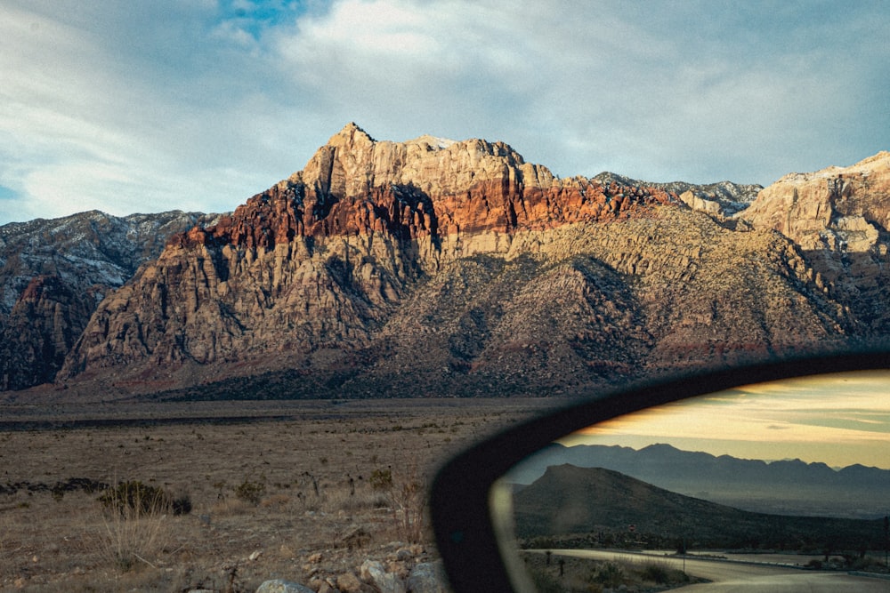 a view of a mountain range from a car's side view mirror