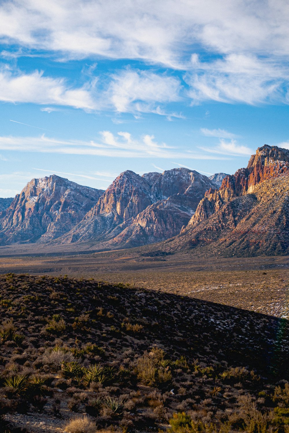 a mountain range with a few clouds in the sky