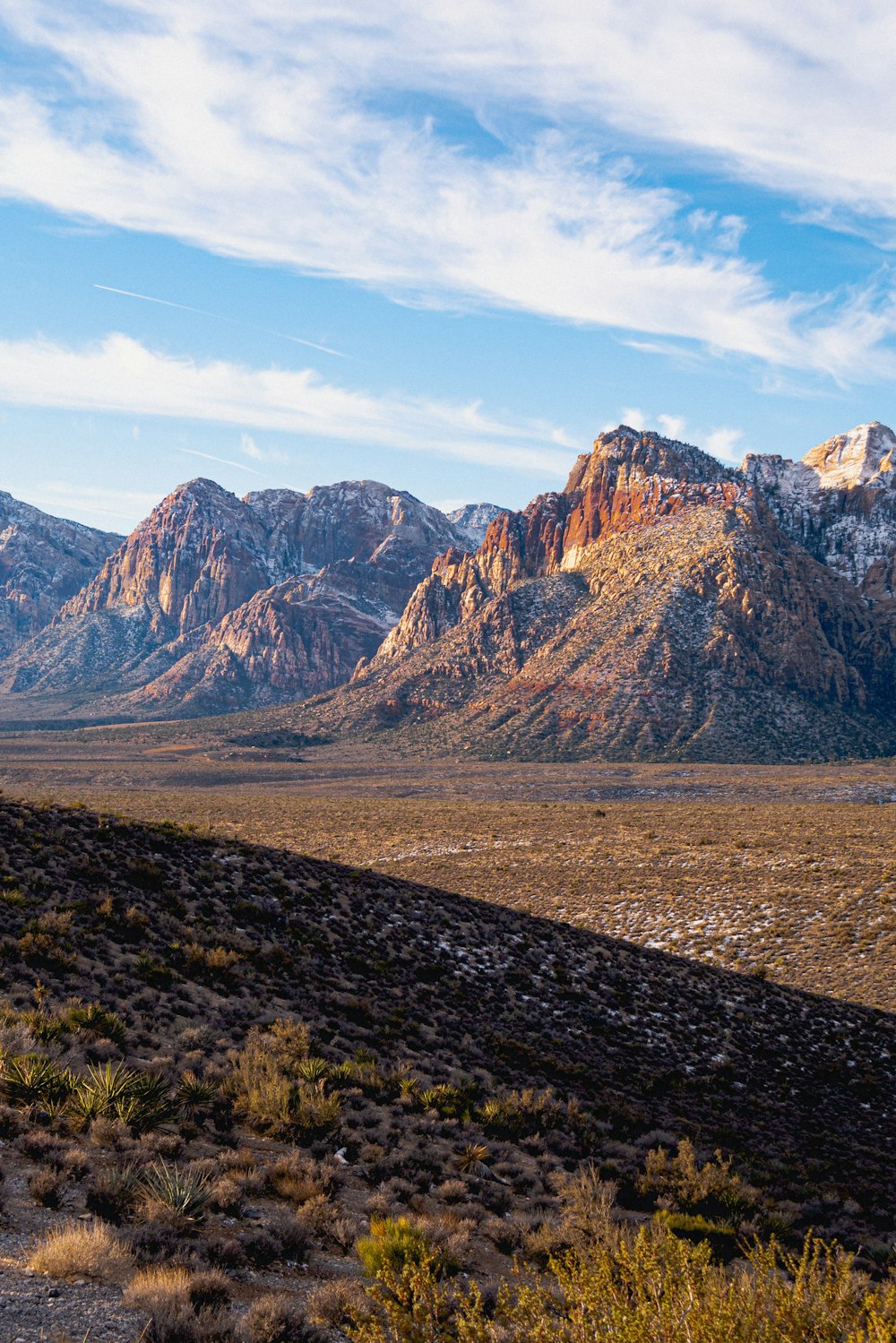 a man riding a horse in the desert with mountains in the background