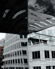 Jaecoo J8 SHS Ardis in a modern city environment with reflections on glass buildings.