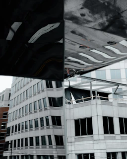 Jaecoo J8 SHS Ardis in a modern city environment with reflections on glass buildings.