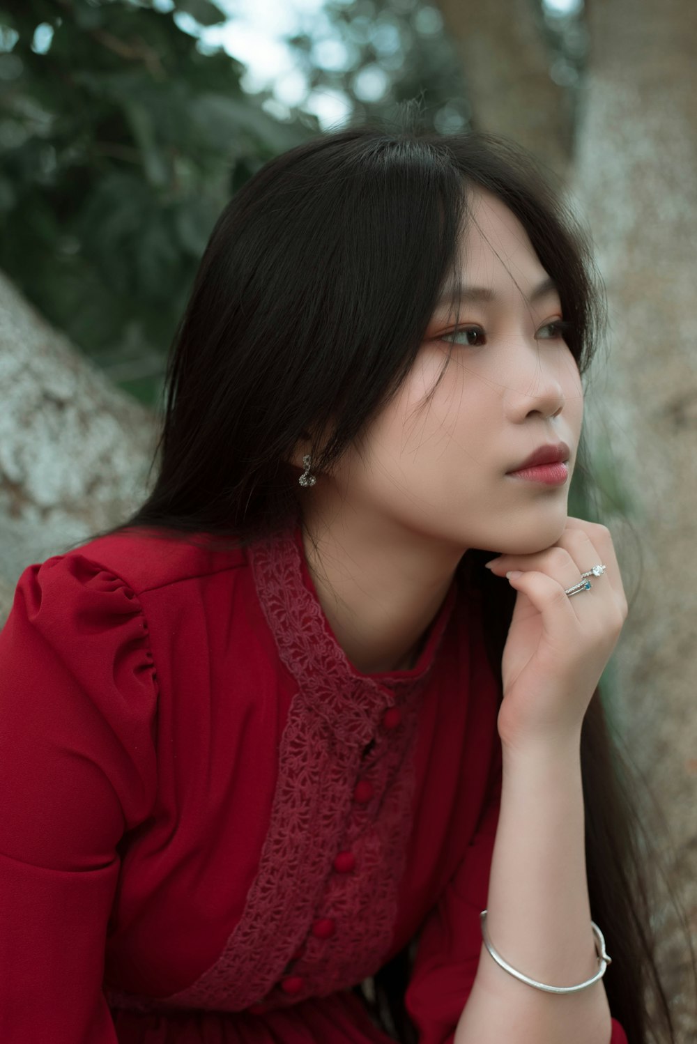 Une femme en robe rouge assise sur un arbre