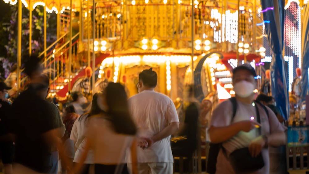 a group of people standing around a carnival ride