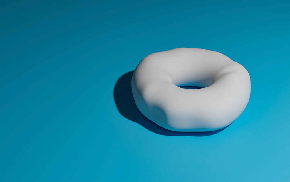 un beignet blanc posé sur une surface bleue