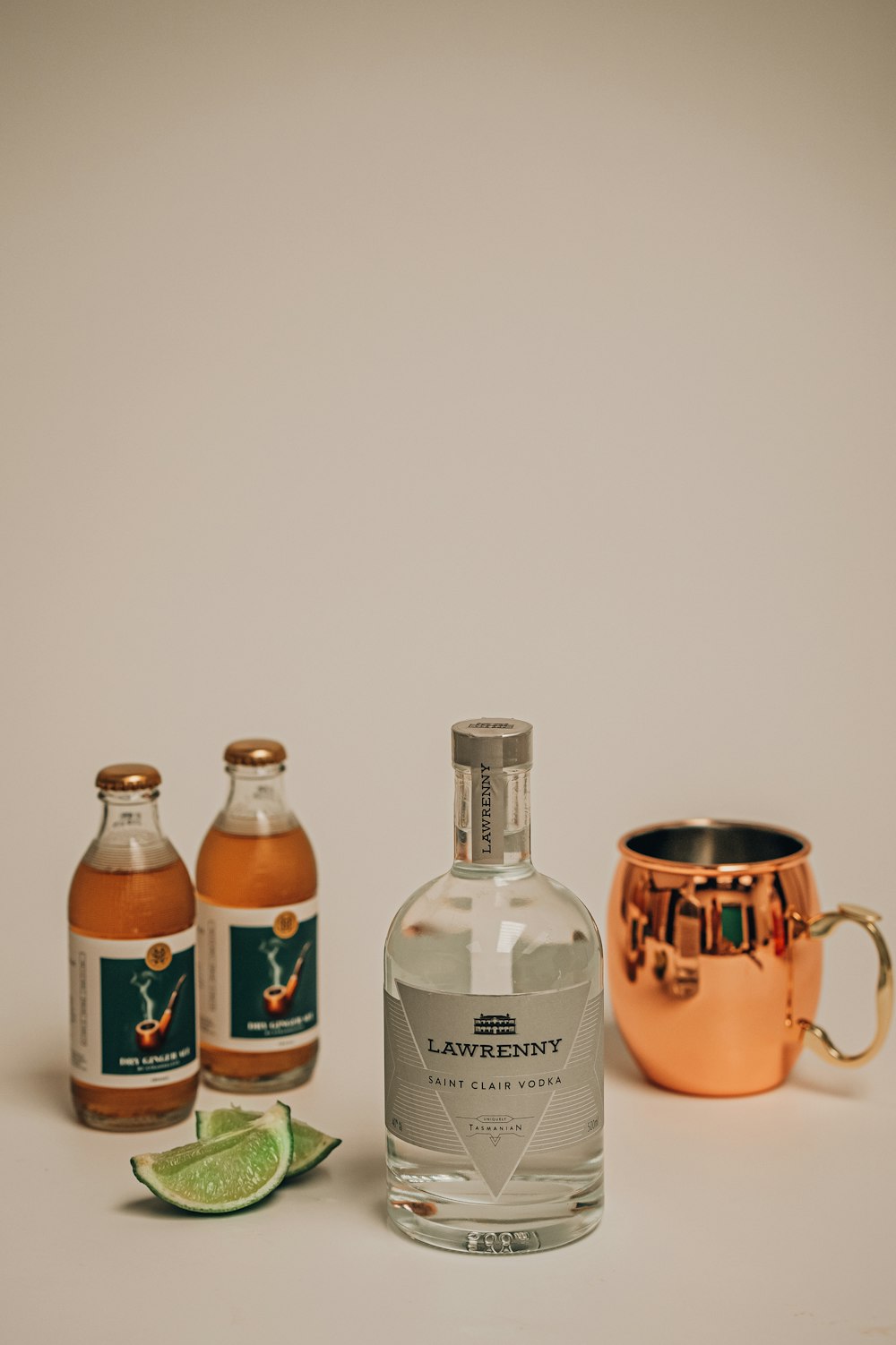 a bottle of liquor next to a copper cup