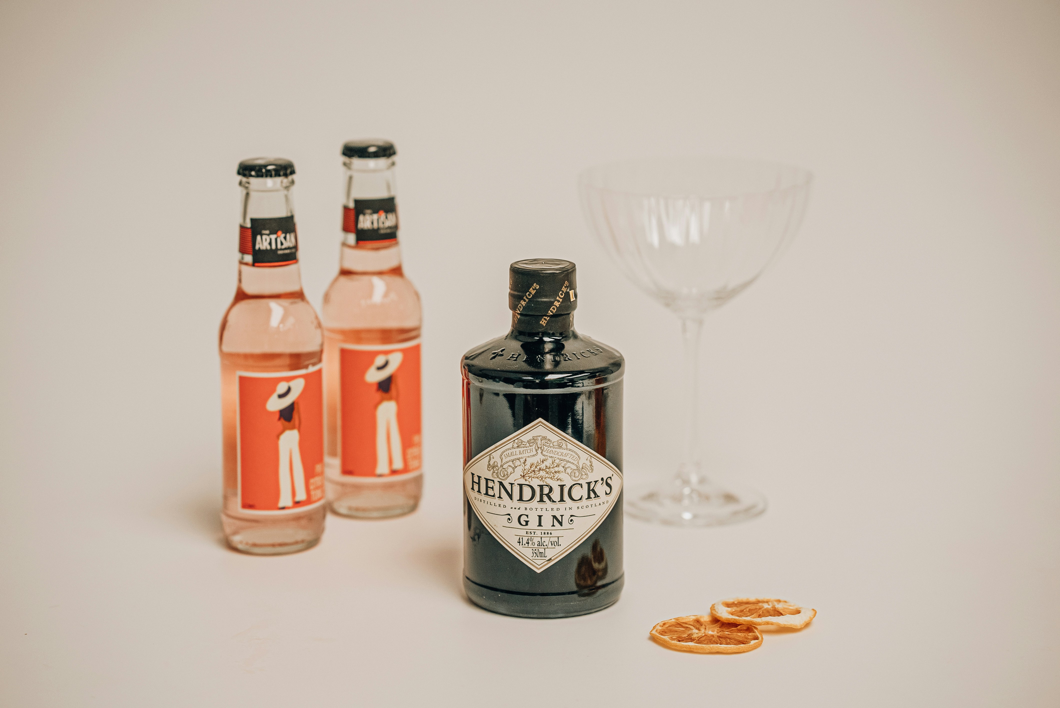 three bottles of gin and a glass on a table