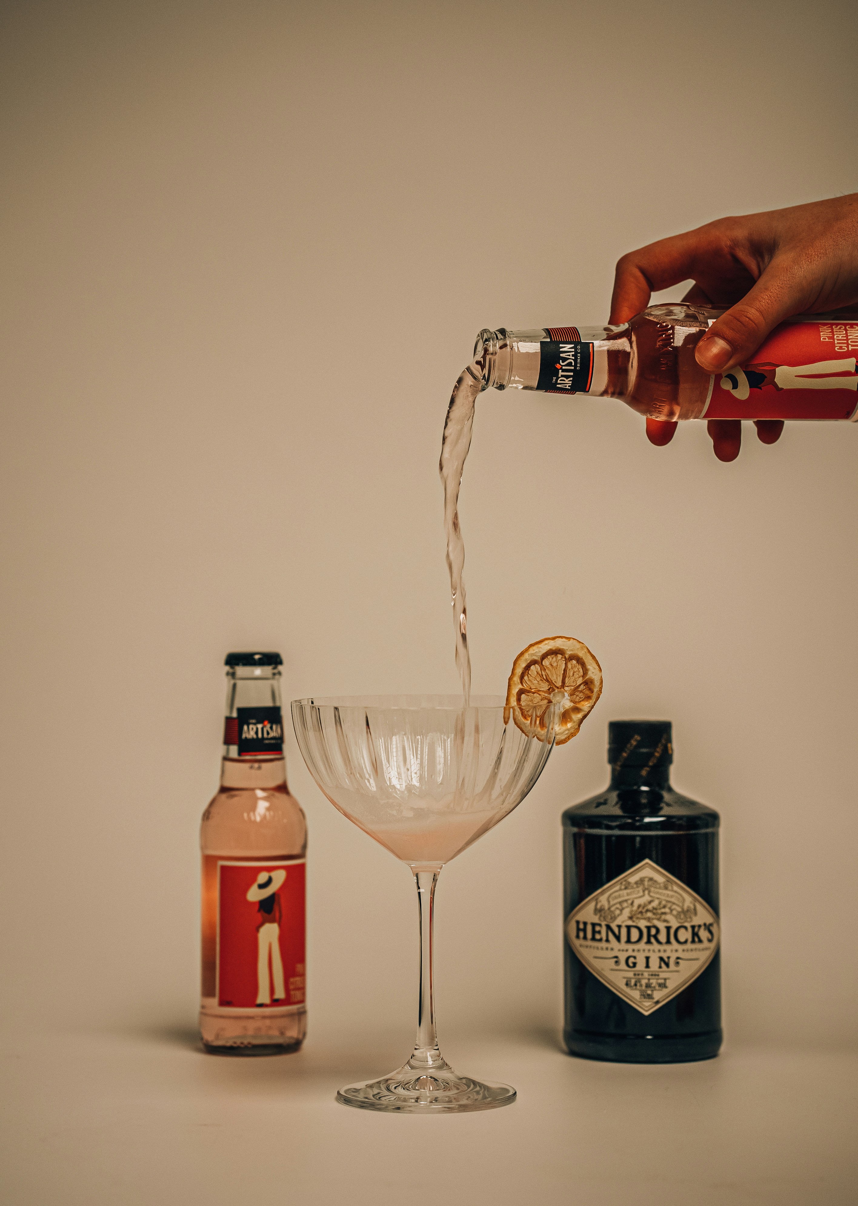 a person pouring a drink into a glass