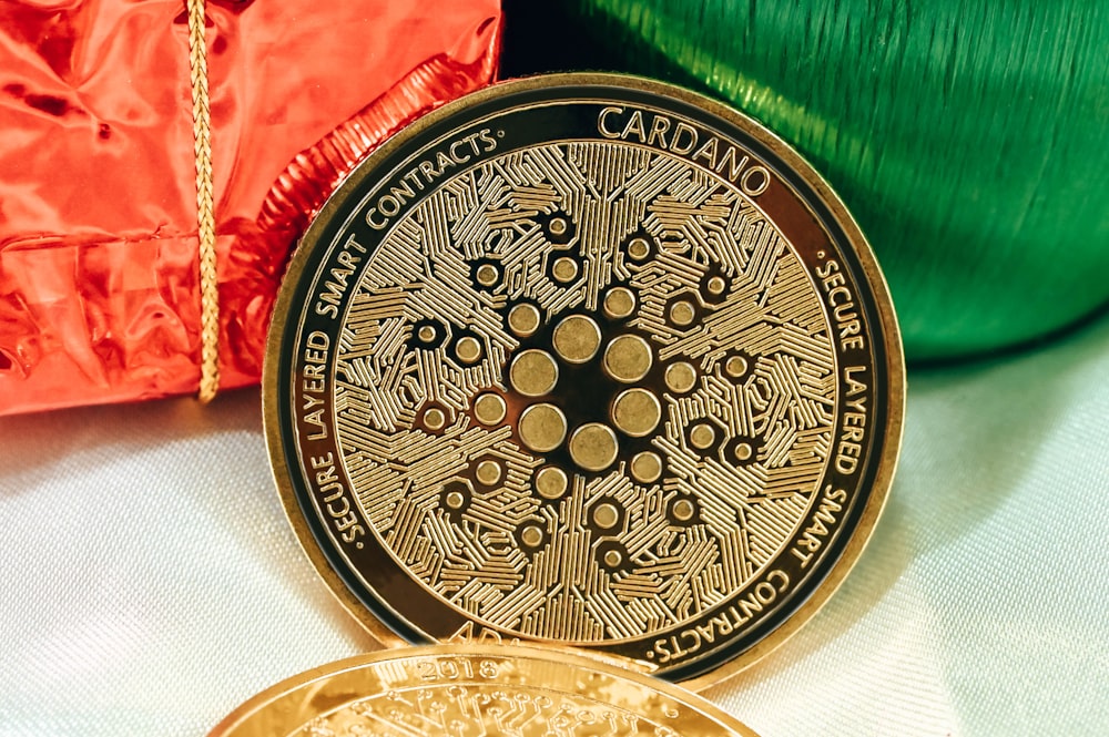 Una moneda de oro sentada junto a una bolsa roja