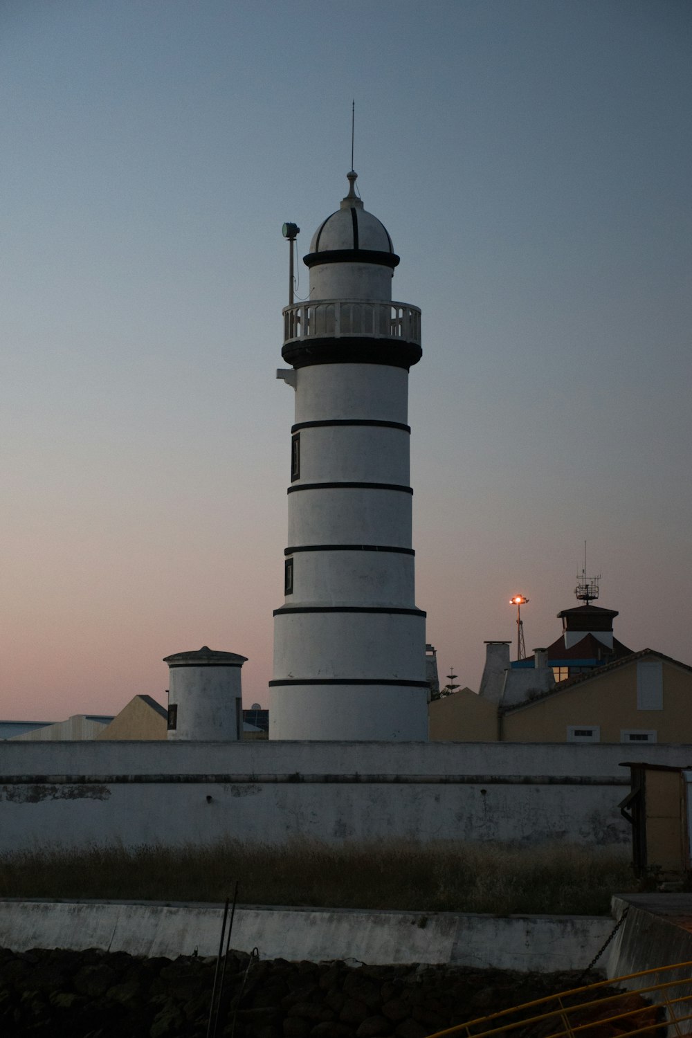 un grand phare blanc et noir au sommet d’un bâtiment