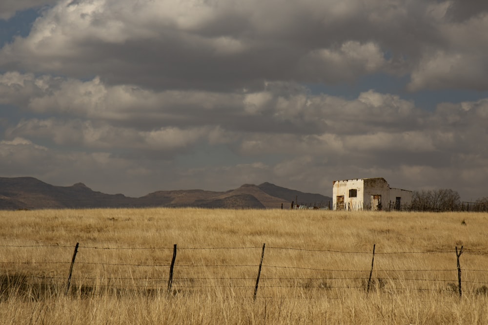 a house in a field with mountains in the background