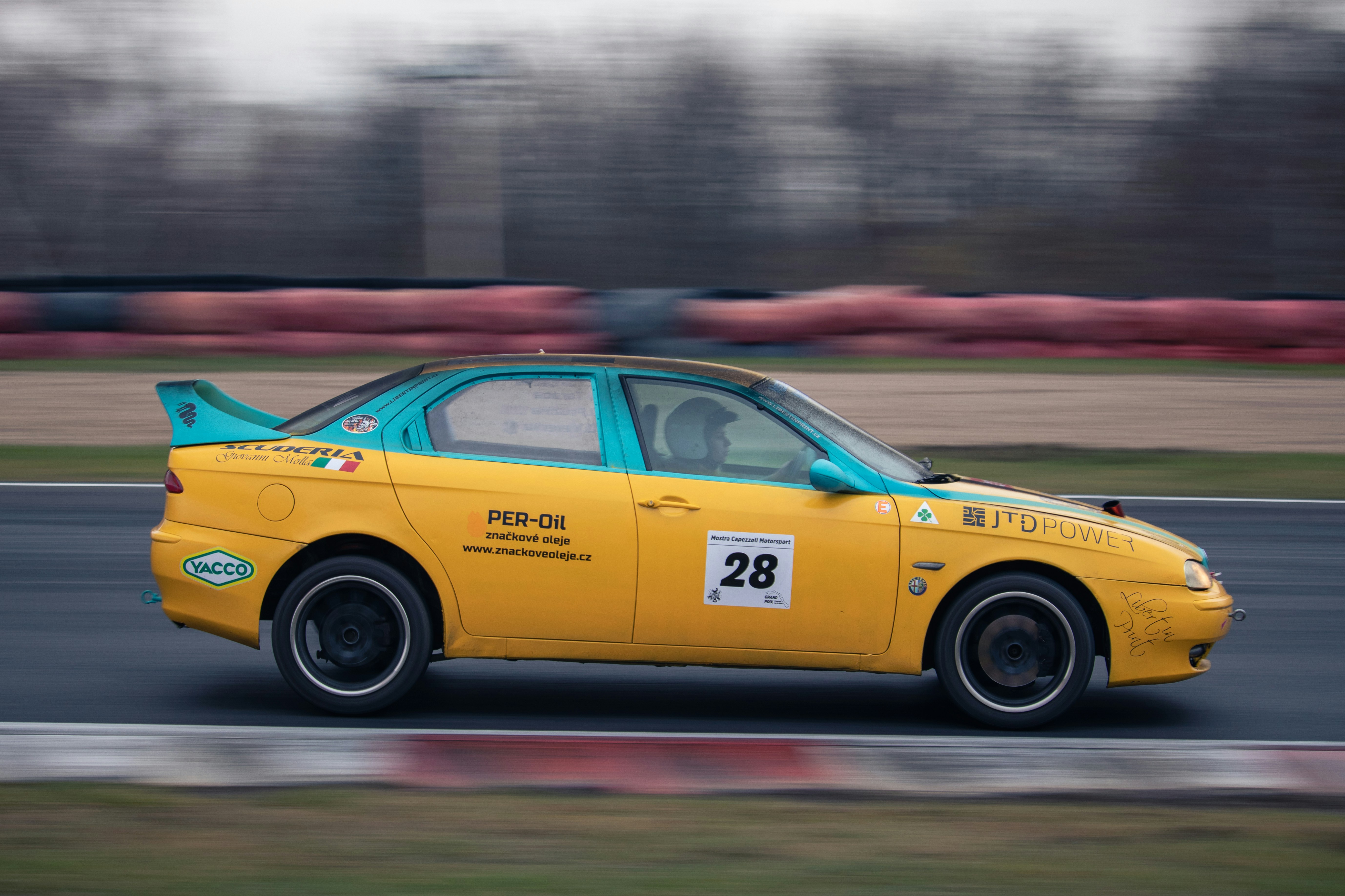 a yellow car driving down a race track