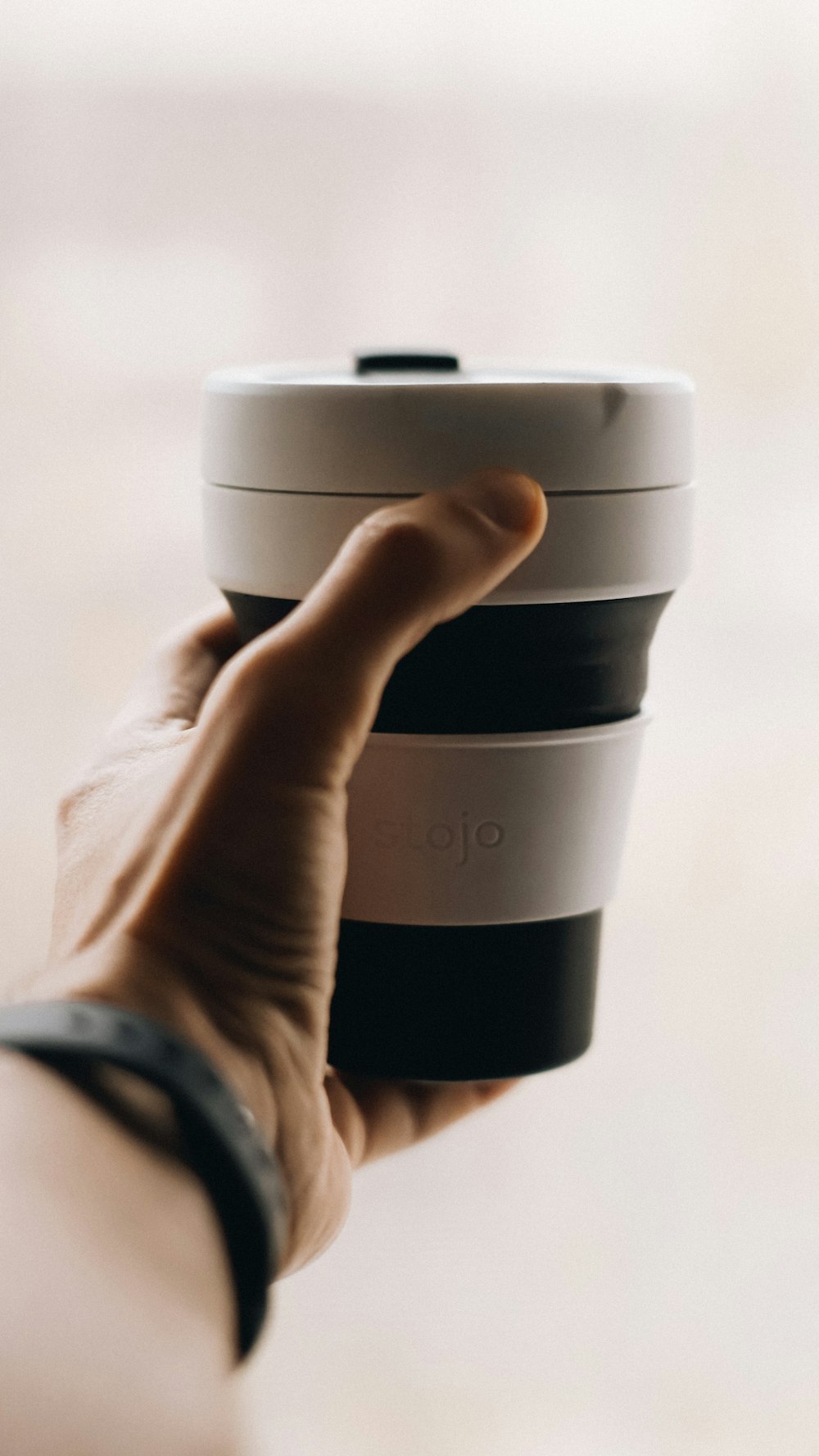 a person holding a cup of coffee in their hand