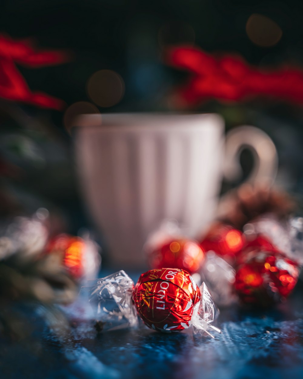 a cup of coffee and some candy on a table