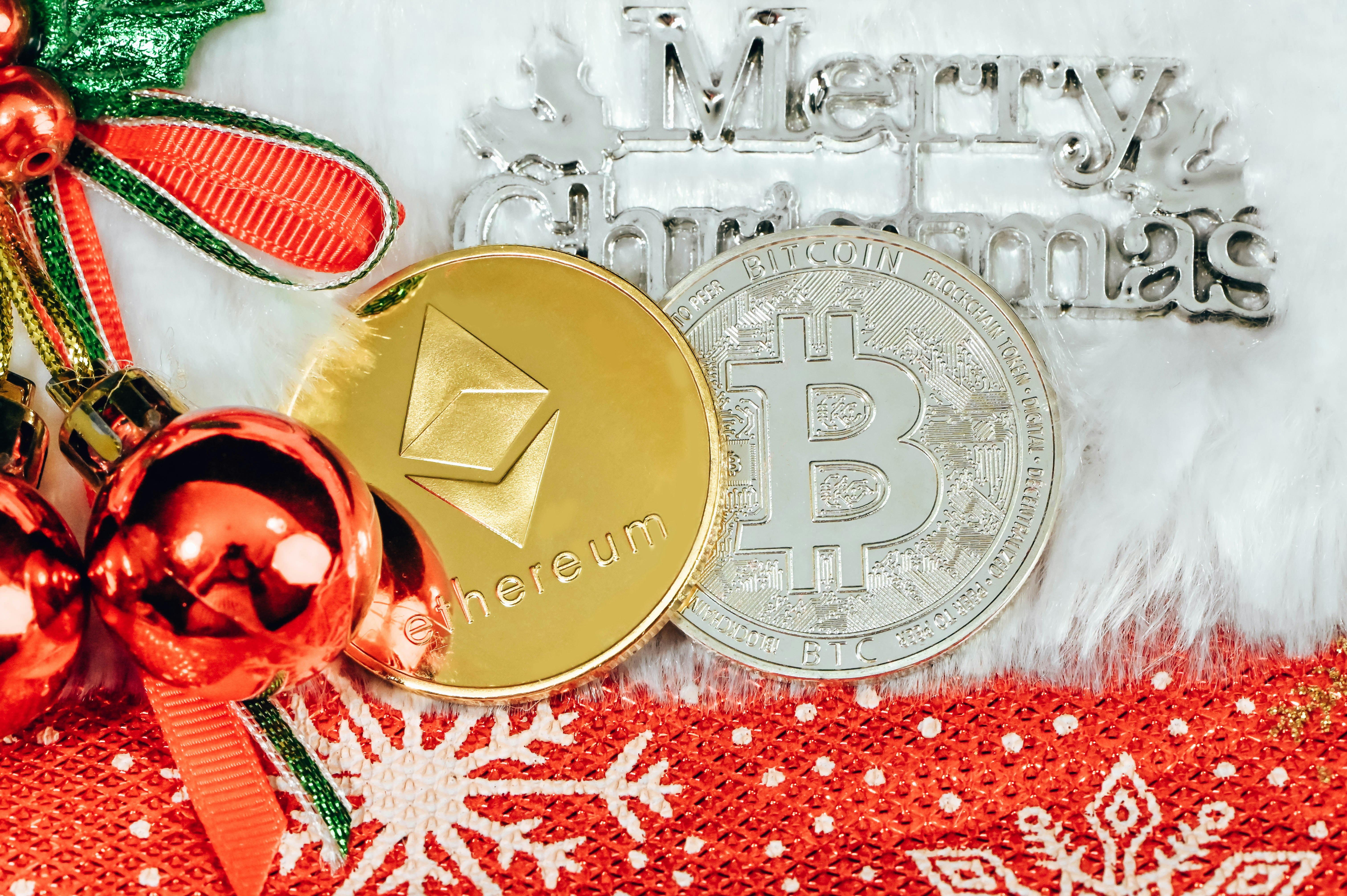 Ethereum coin and Bitcoin under a Merry Christmas sign