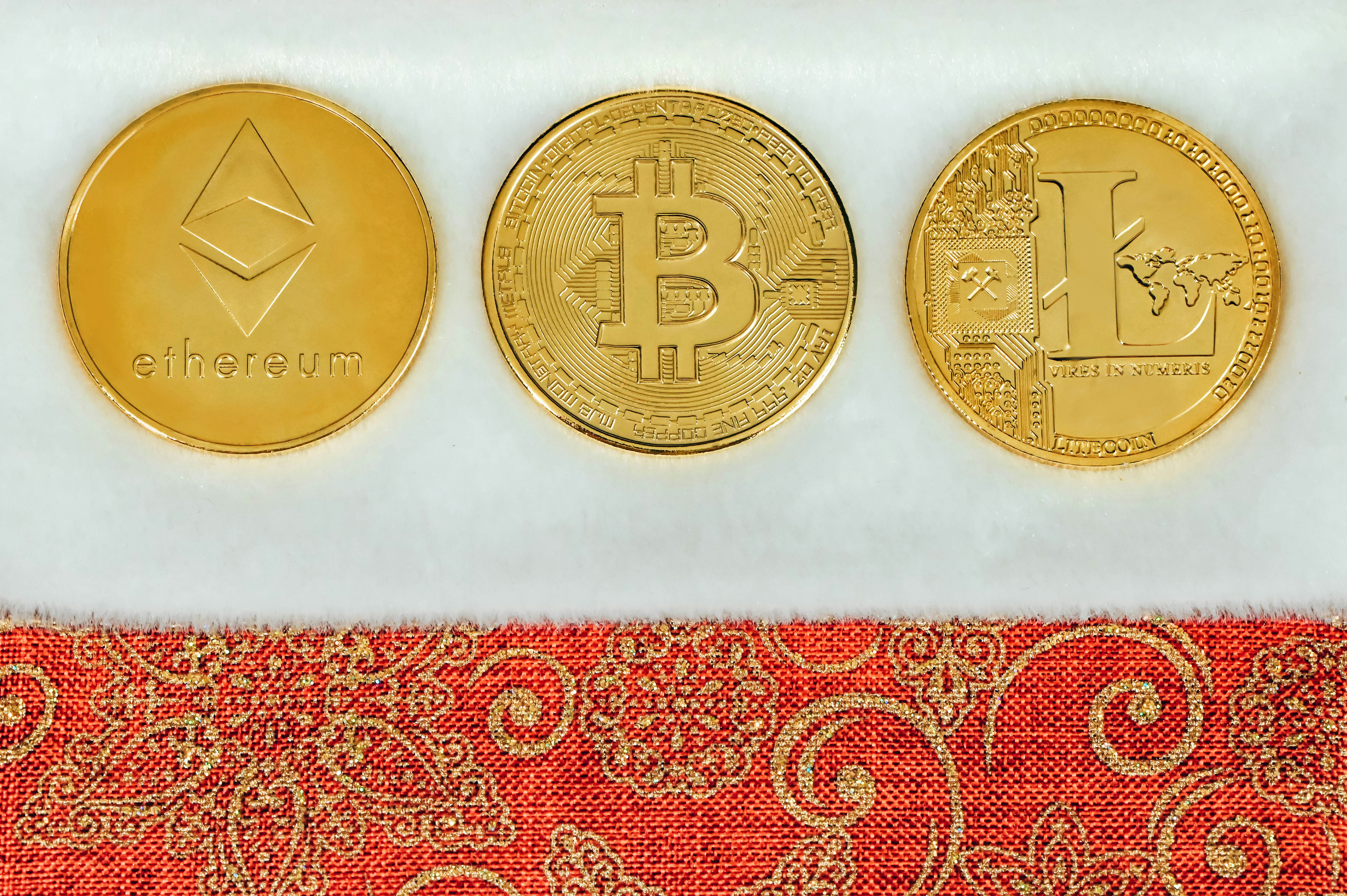 three gold bitcoins sitting next to each other