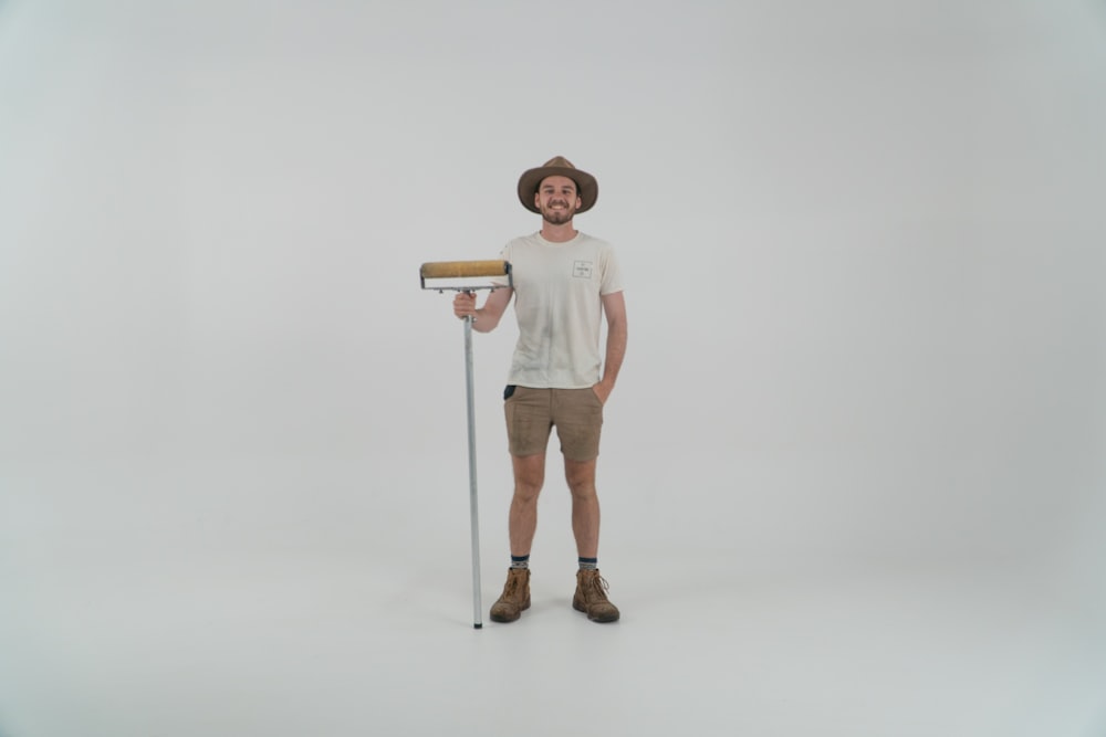 a man is holding a paint roller and smiling