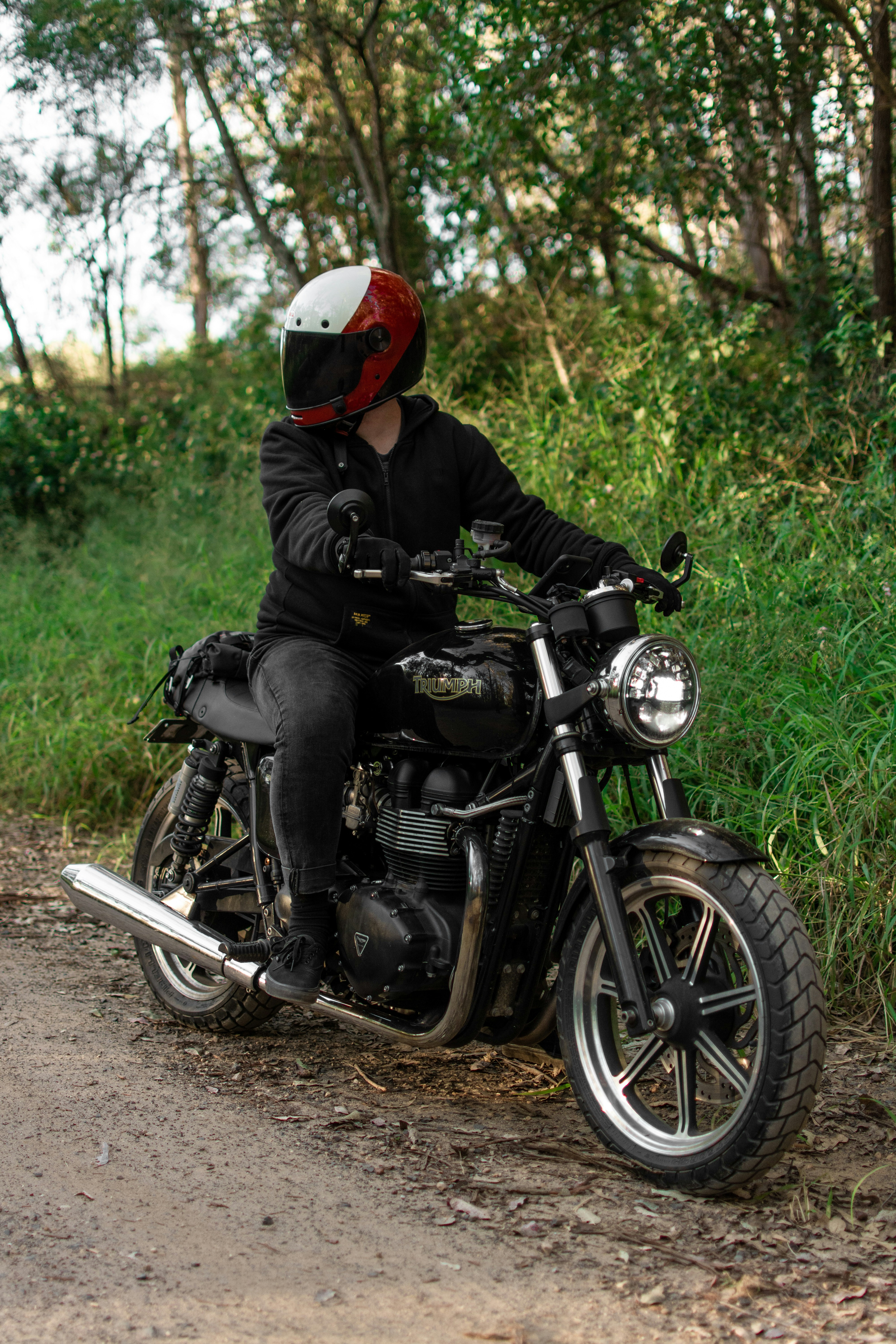 a man riding a motorcycle down a dirt road
