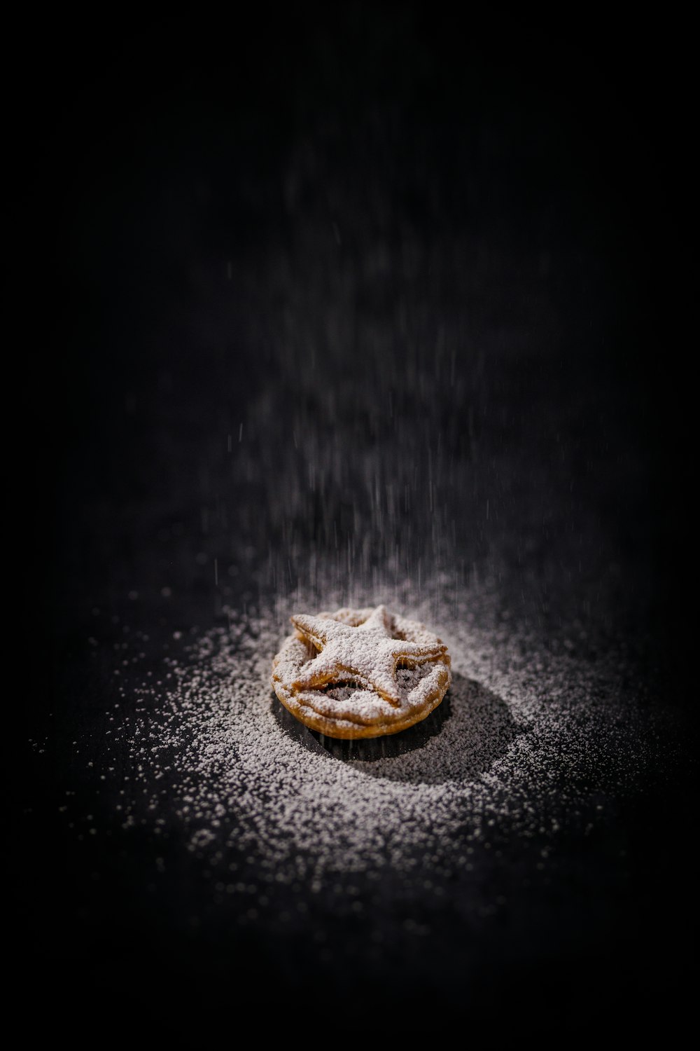 a powdered pastry sitting on top of a black table
