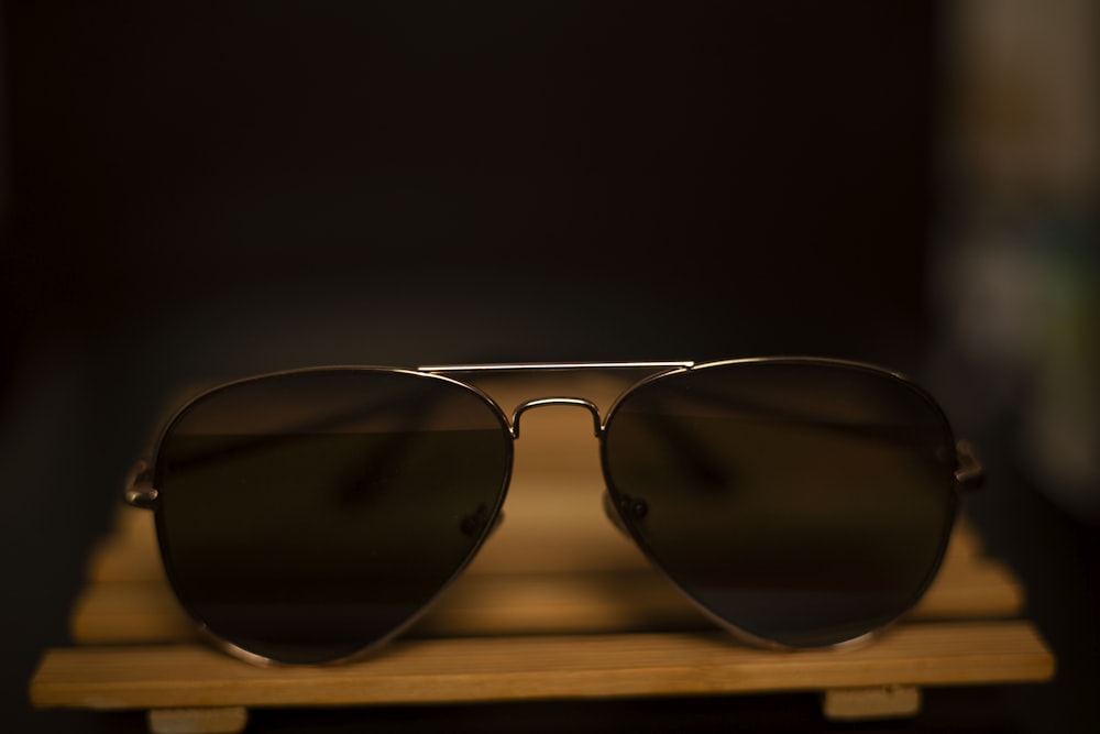 a pair of sunglasses sitting on top of a wooden stand