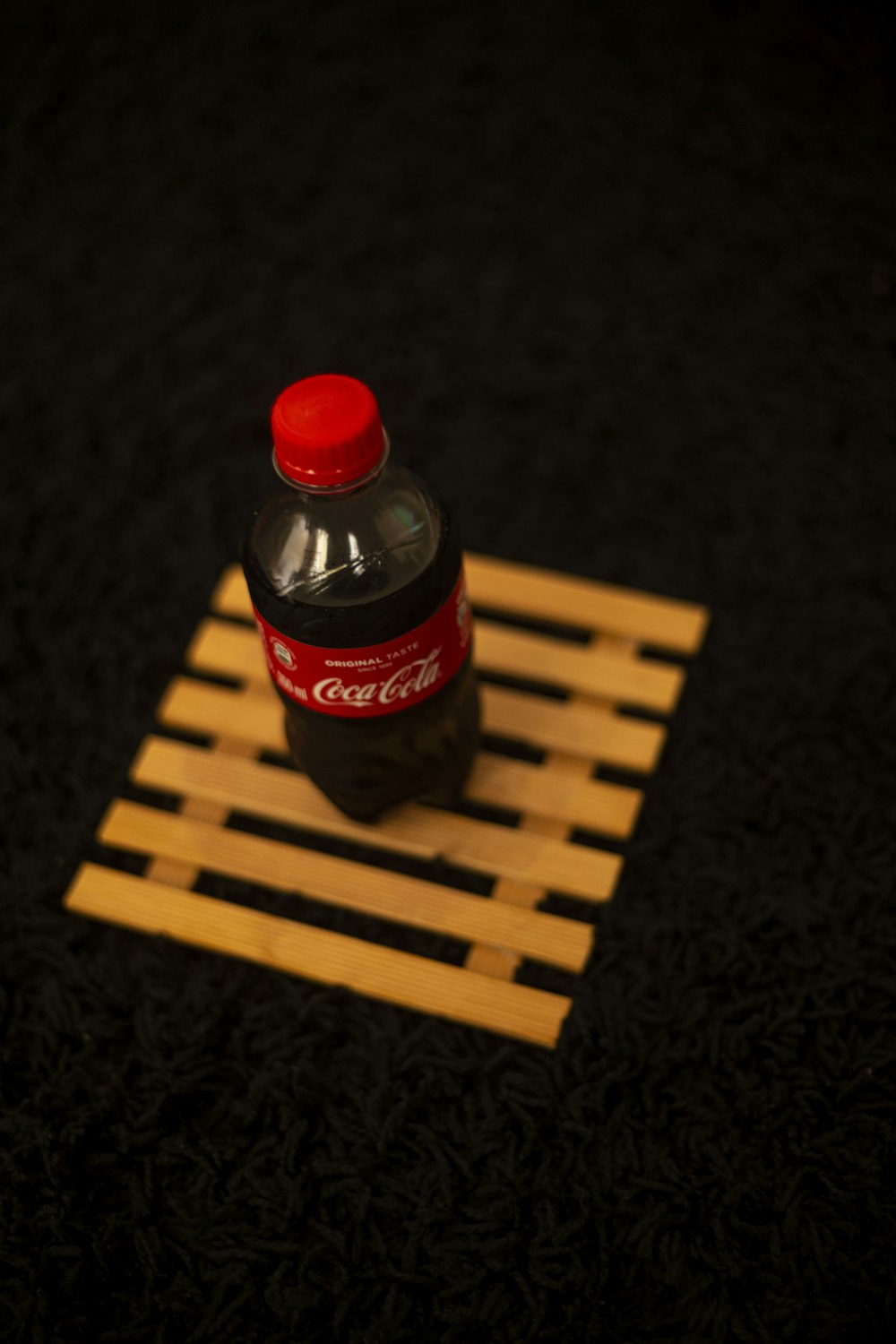 a bottle of coca cola sitting on top of a wooden crate