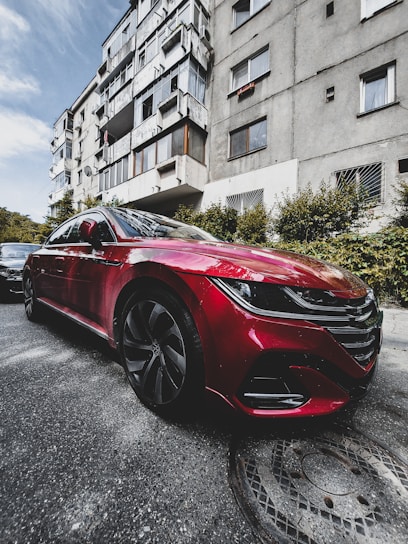 A shiny, well-maintained car parked outside a cozy urban apartment, ready for a new driver.