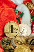 a pile of gold bitcoins and a santa hat