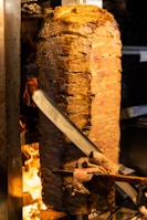 a large piece of meat is being cooked on a grill