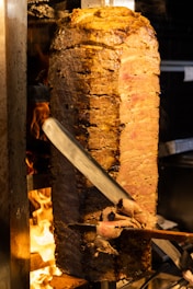 a large piece of meat is being cooked on a grill