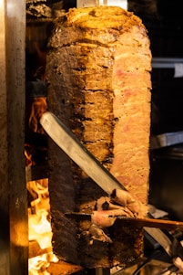 a large piece of meat is being cooked on a grill