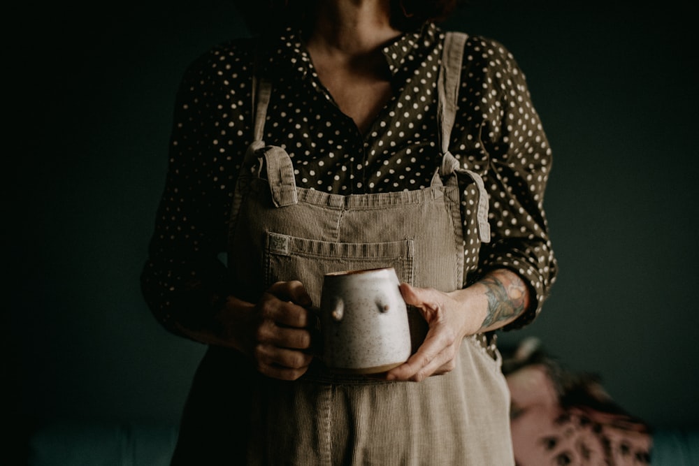 Une femme tenant une tasse dans ses mains