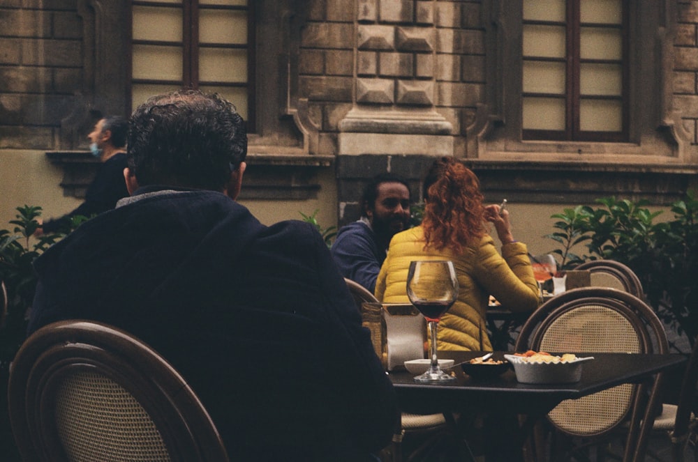 um grupo de pessoas sentadas em uma mesa do lado de fora