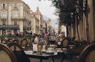 A cozy café terrace bustling with people in a European city.