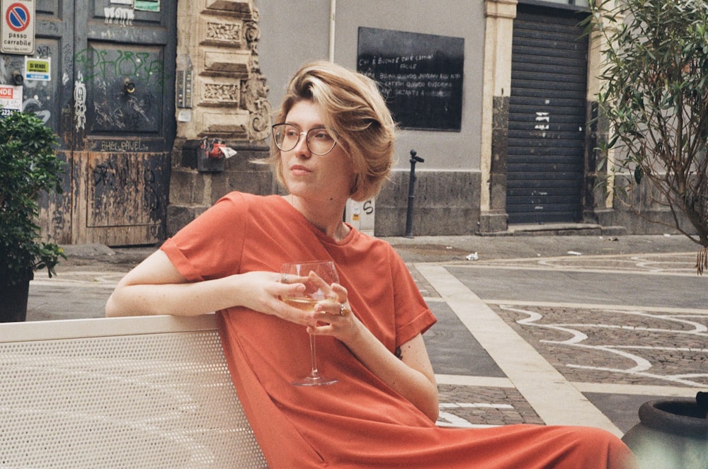 a woman sitting on a bench with a glass of wine