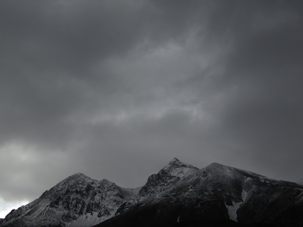 a snow covered mountain under a cloudy sky