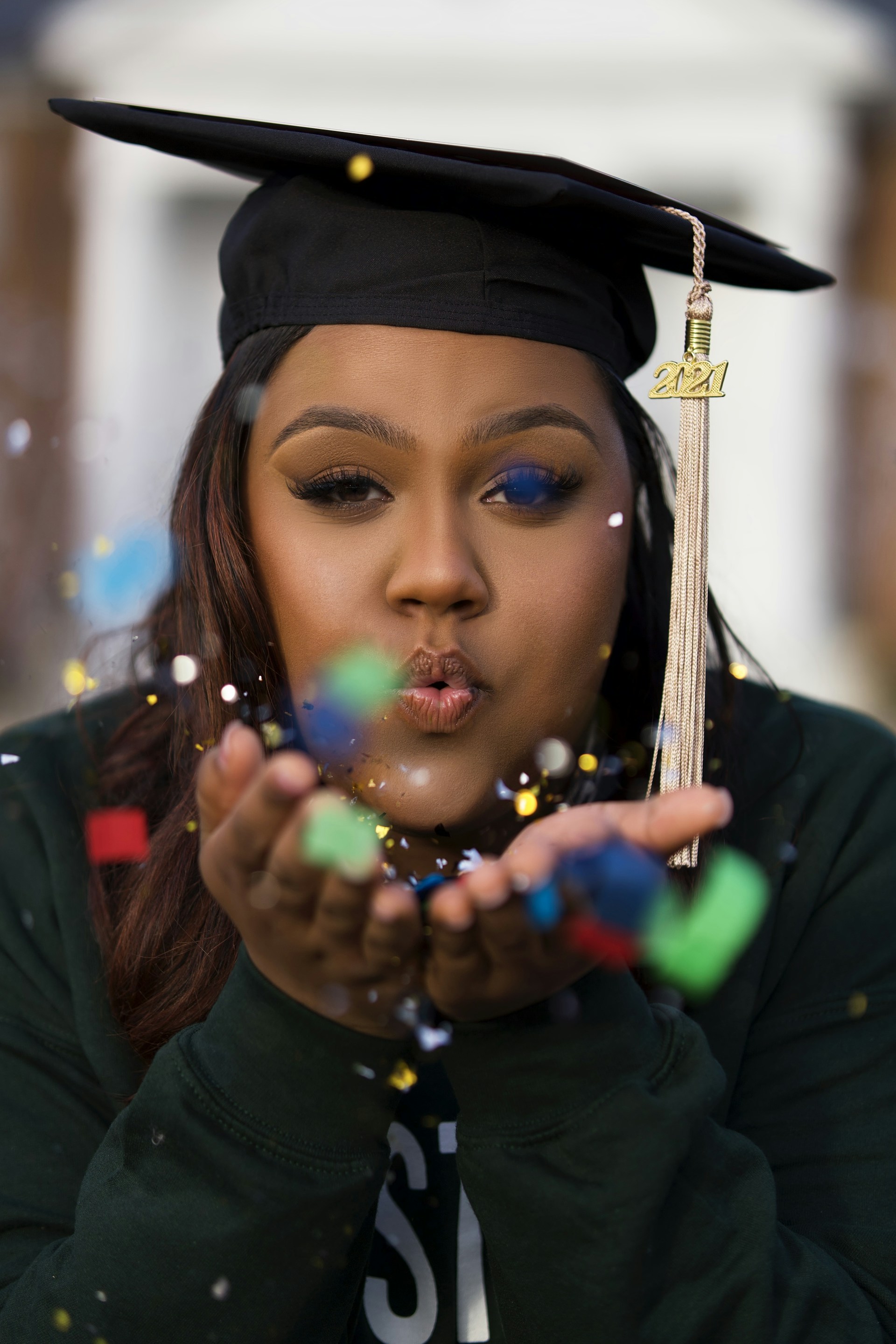 a woman in a graduation cap blowing bubbles