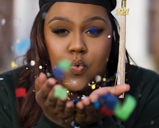 a woman in a graduation cap blowing bubbles