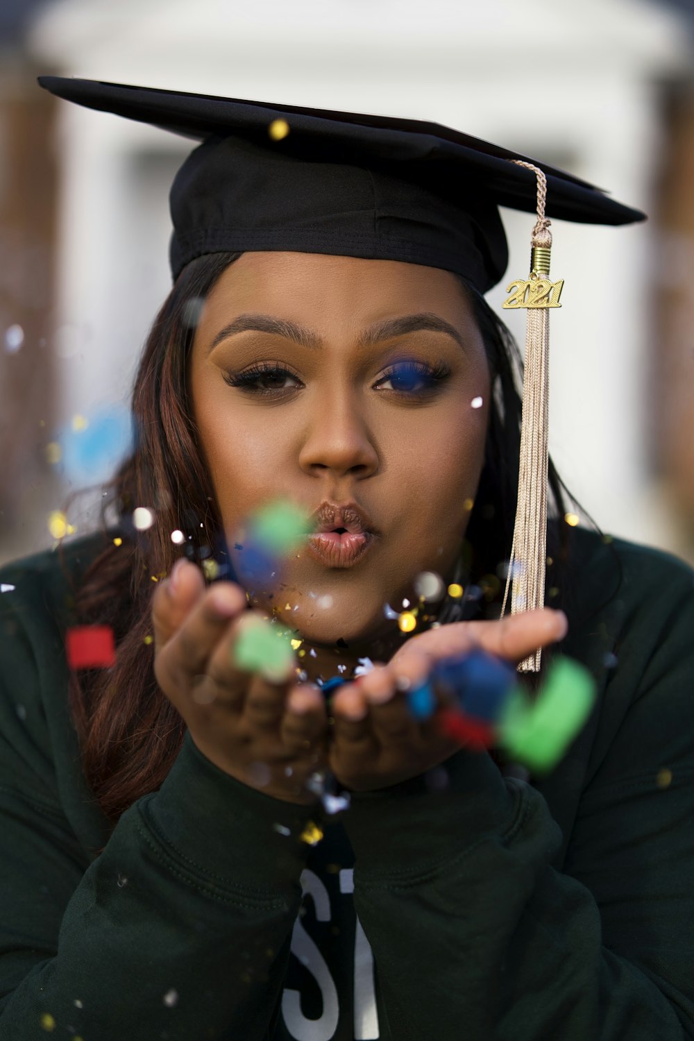 Una donna in un berretto di laurea che soffia bolle