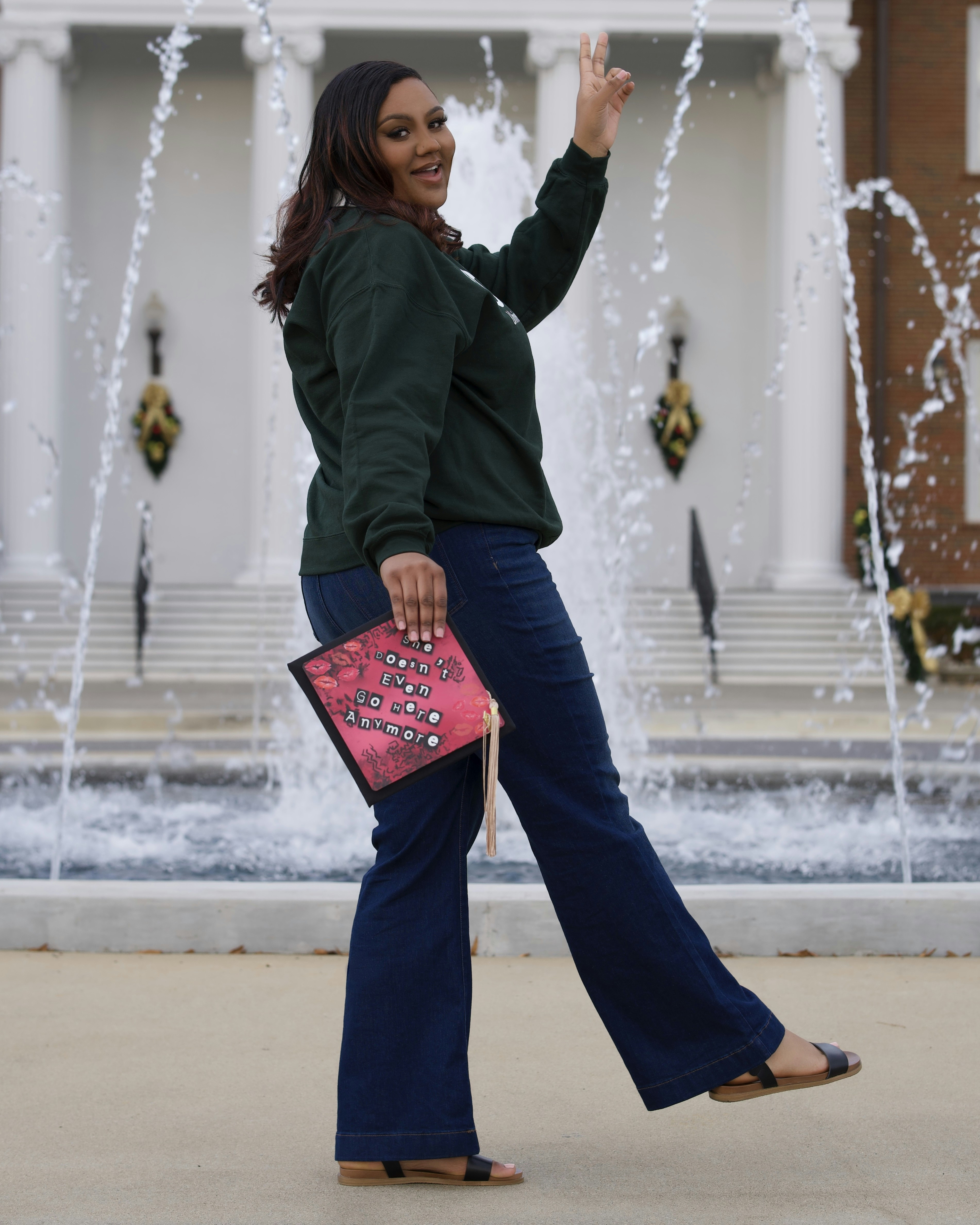 a woman is walking in front of a fountain
