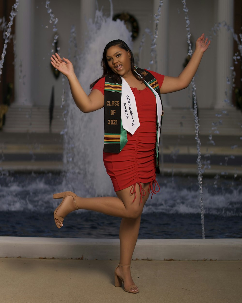 a woman is posing in front of a fountain