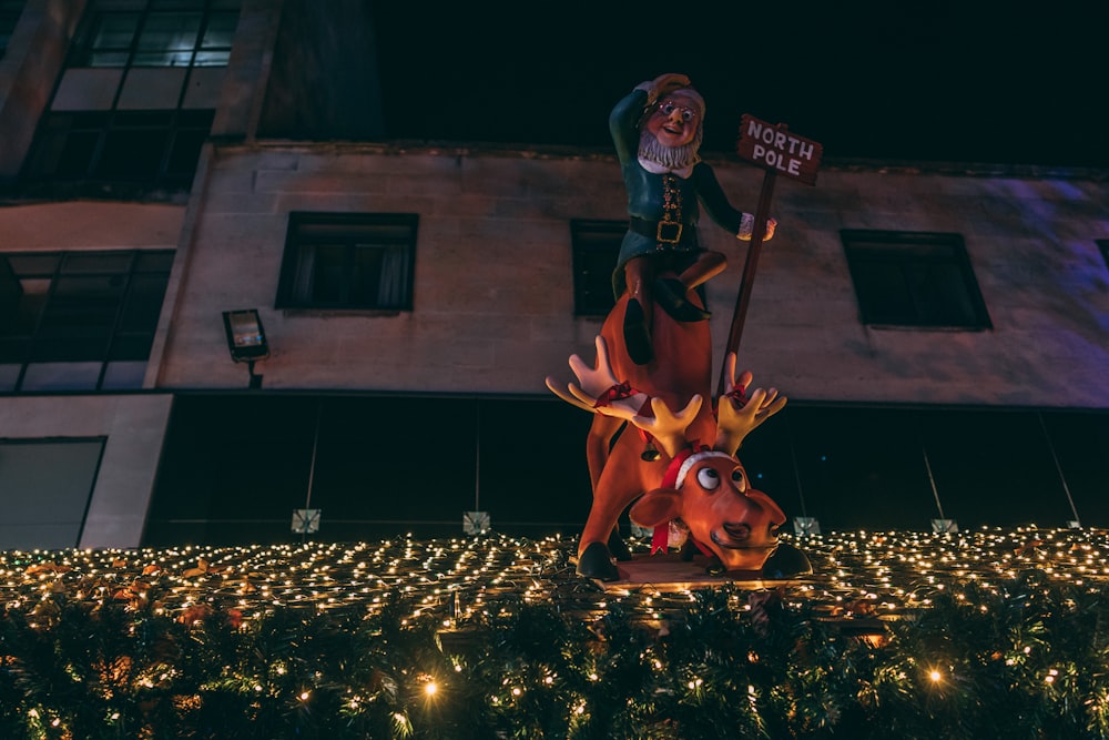 a statue of a man riding a reindeer with a sign