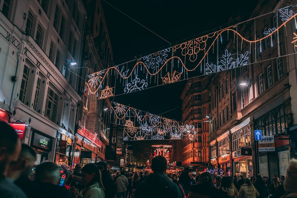 a crowd of people walking down a street at night