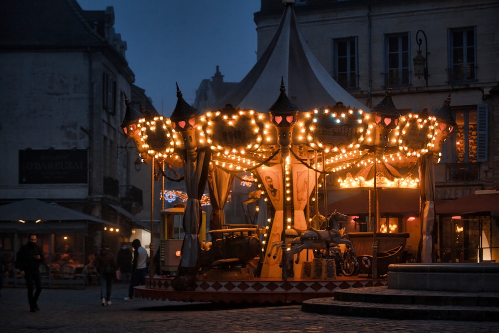 a merry go round is lit up at night