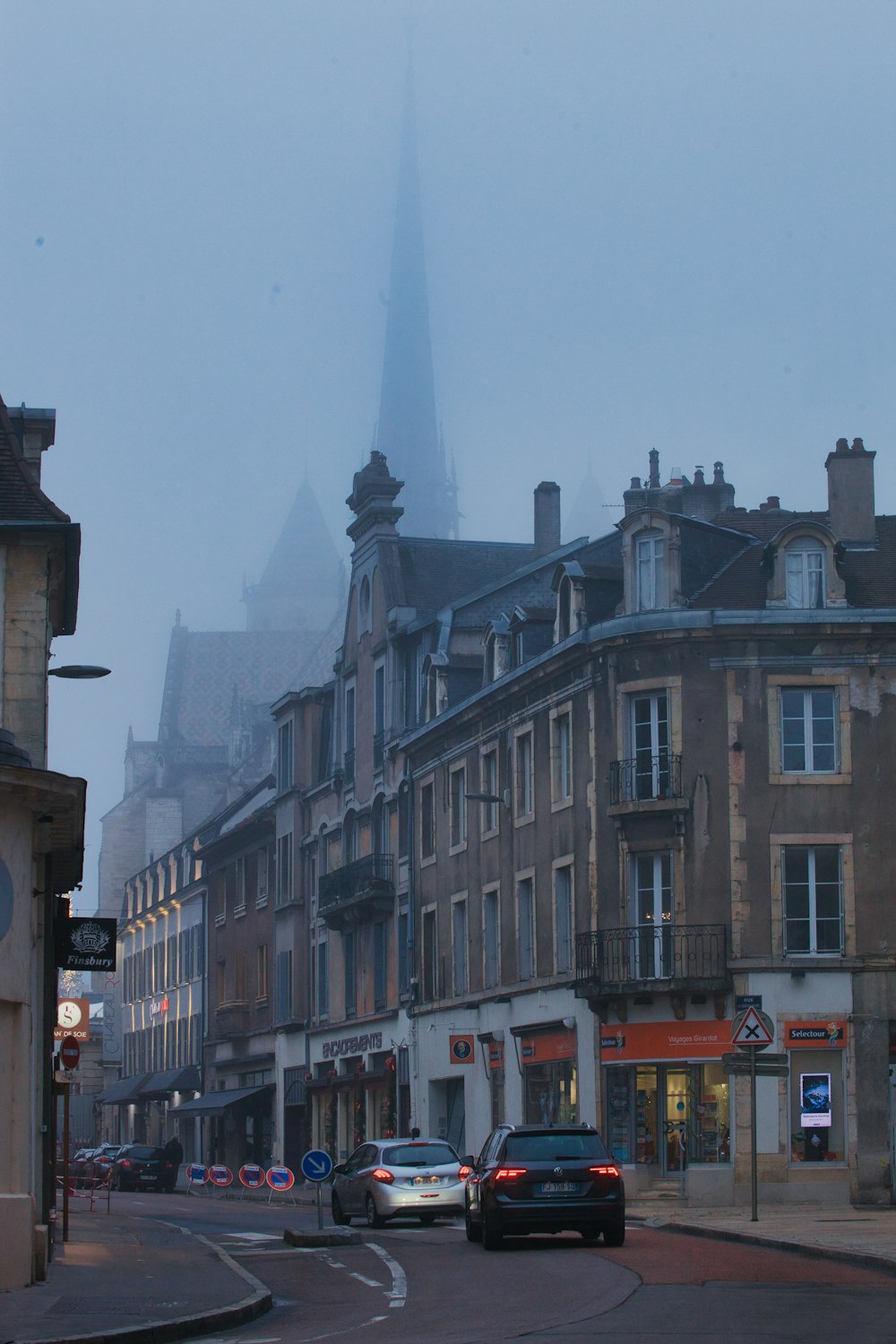 Une rue brumeuse de la ville avec des voitures garées sur le bord de la route