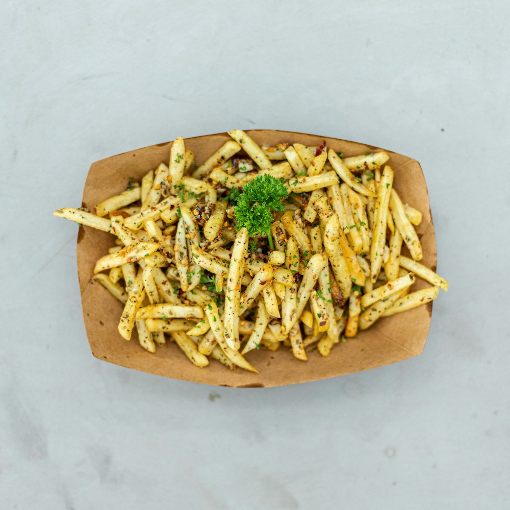 a plate of french fries with a garnish on top