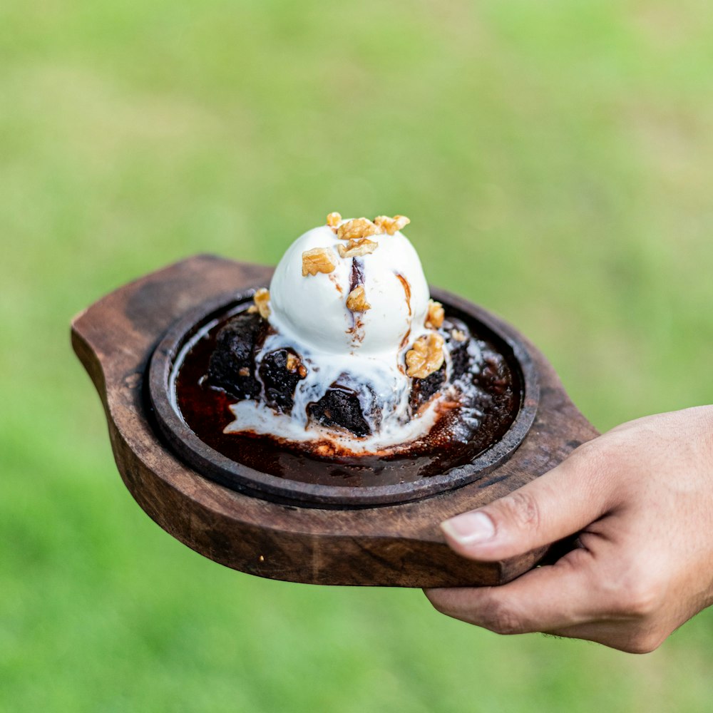 a person holding a plate with a dessert on it