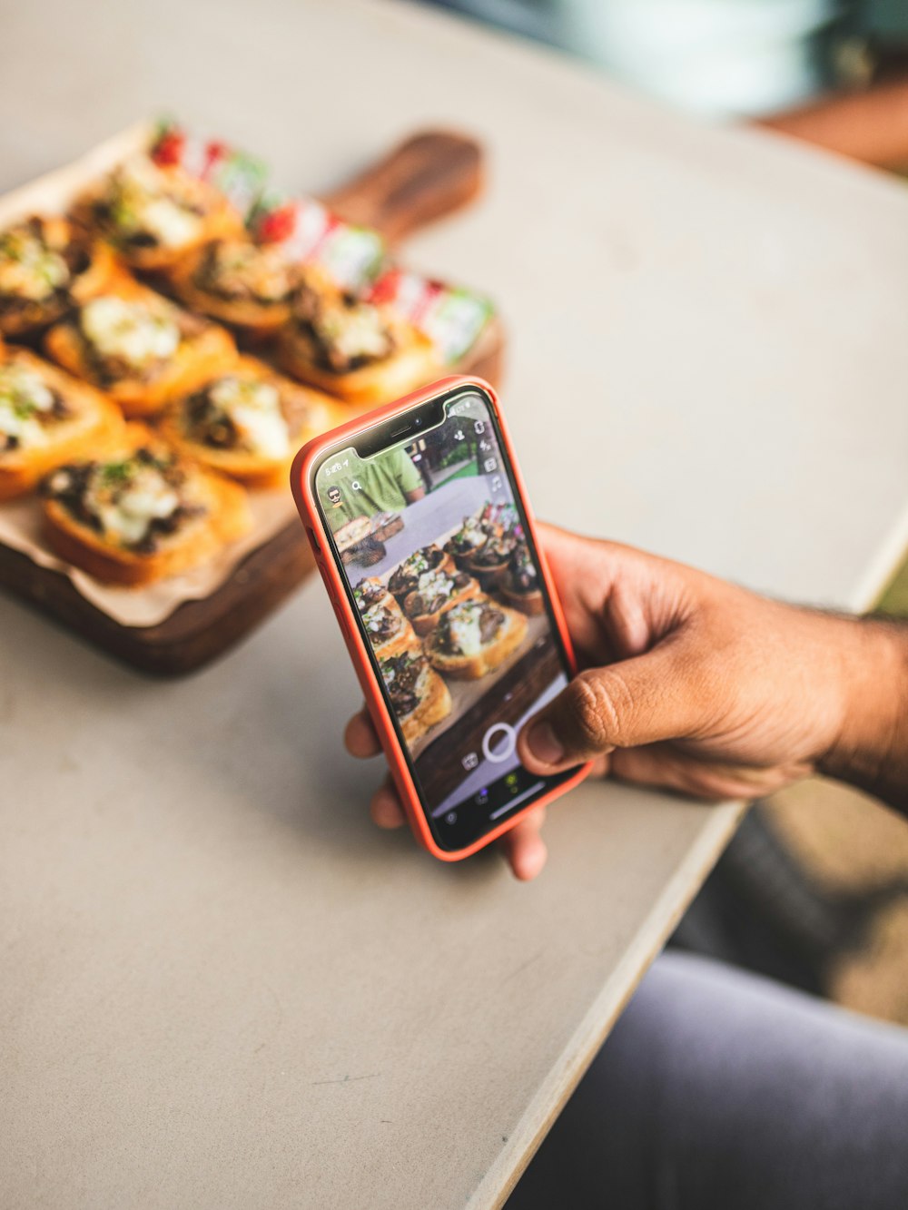 a person taking a picture of food on their cell phone