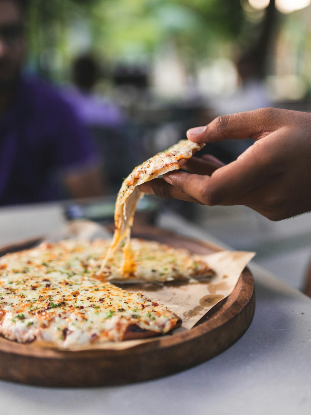 a person is taking a slice of pizza