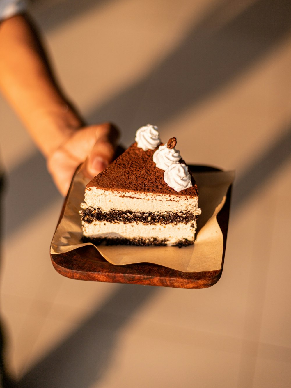 una persona che tiene un pezzo di torta su un piatto