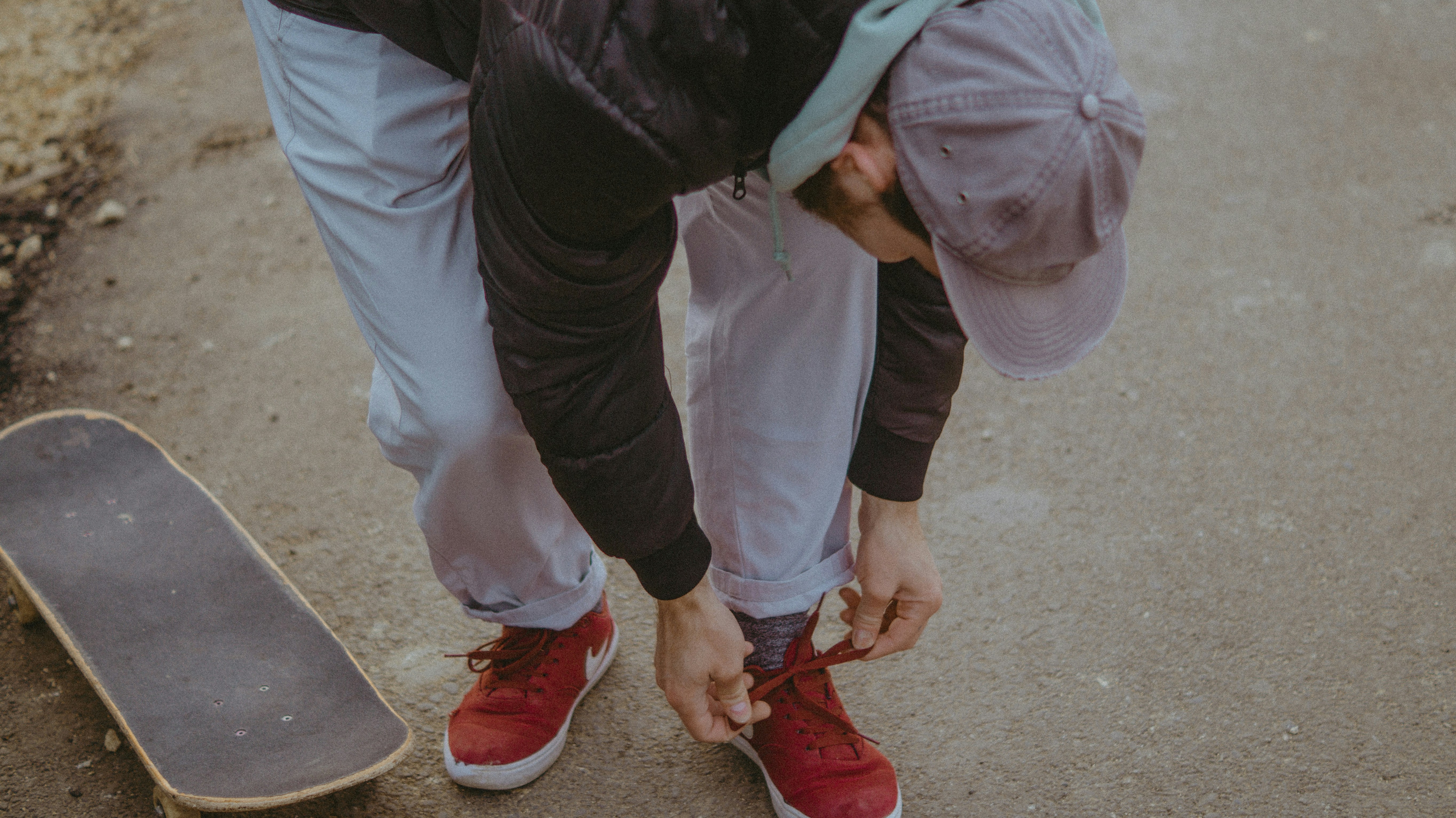 a man bending over to pick up a skateboard