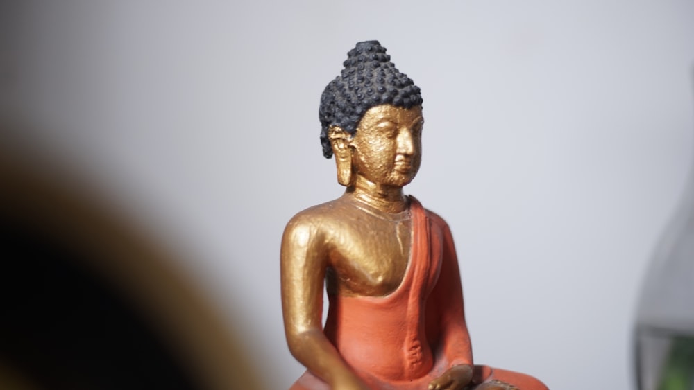 a gold buddha statue sitting on top of a table